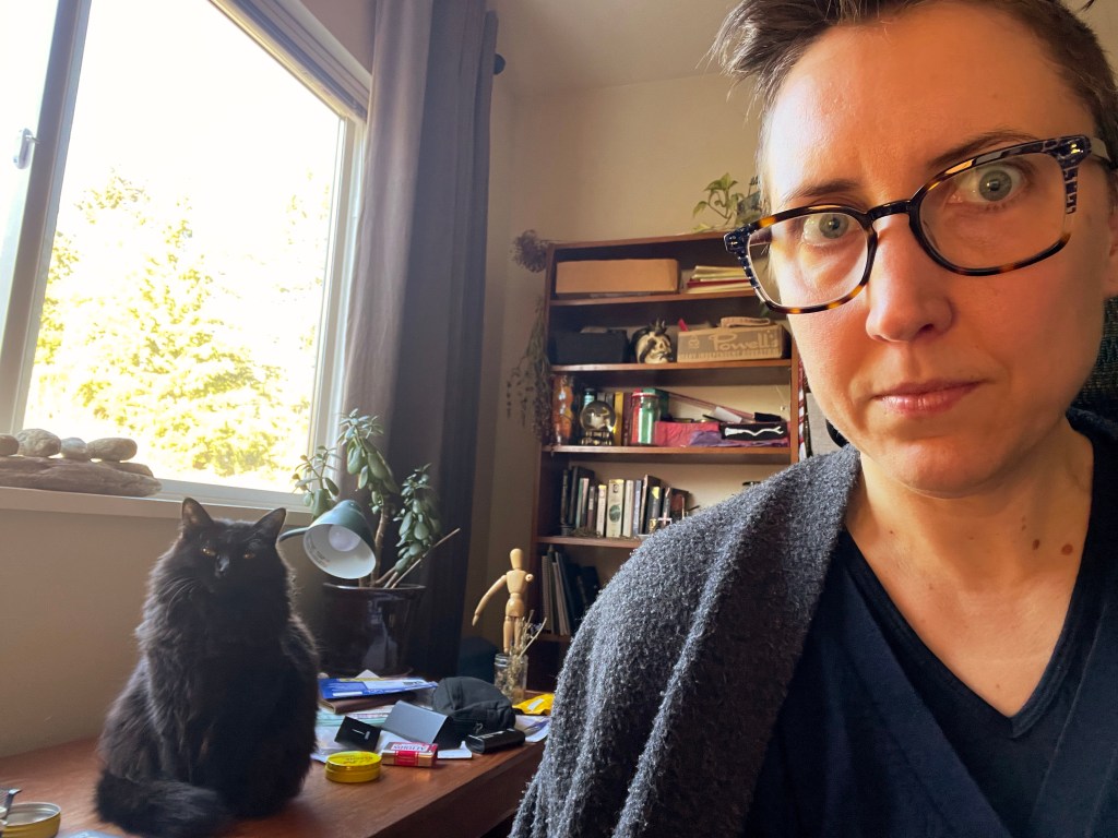 Making eyes at the camera as Luna stares back from her perch on the desk