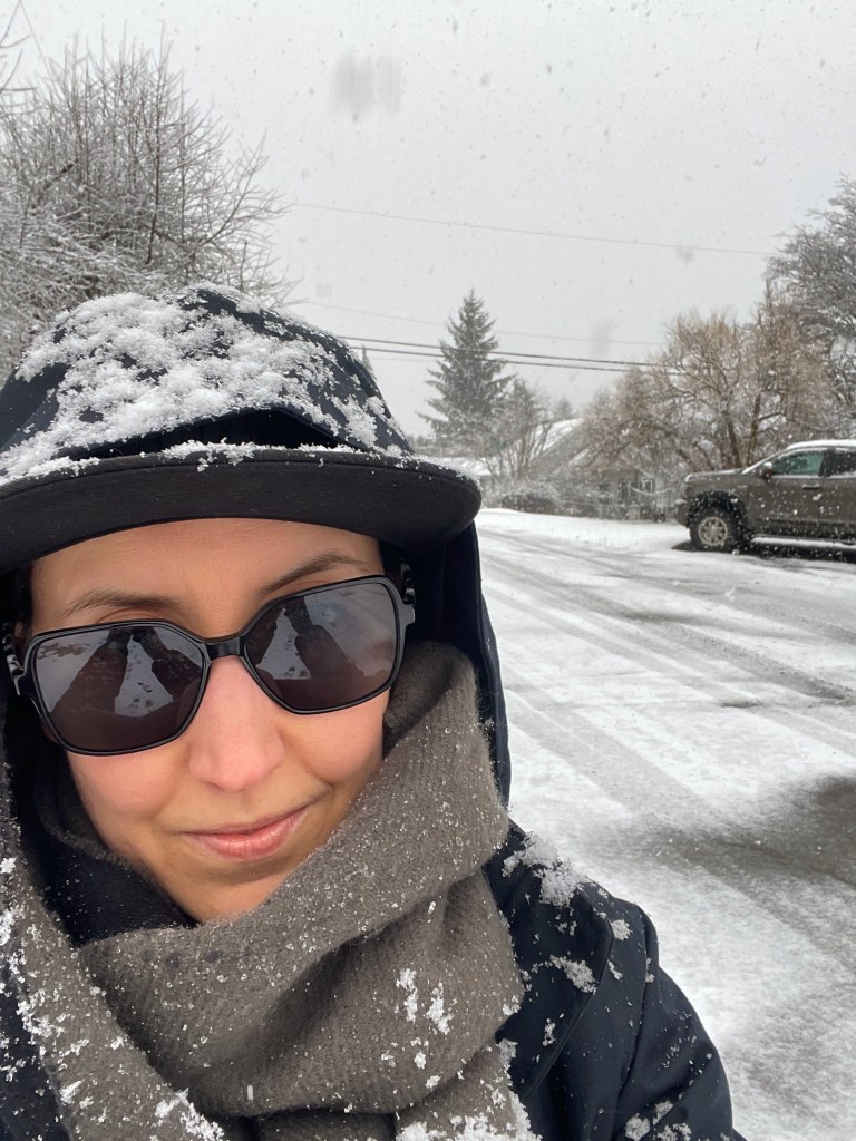 Smiling up at the camera, snow falling all over and around me