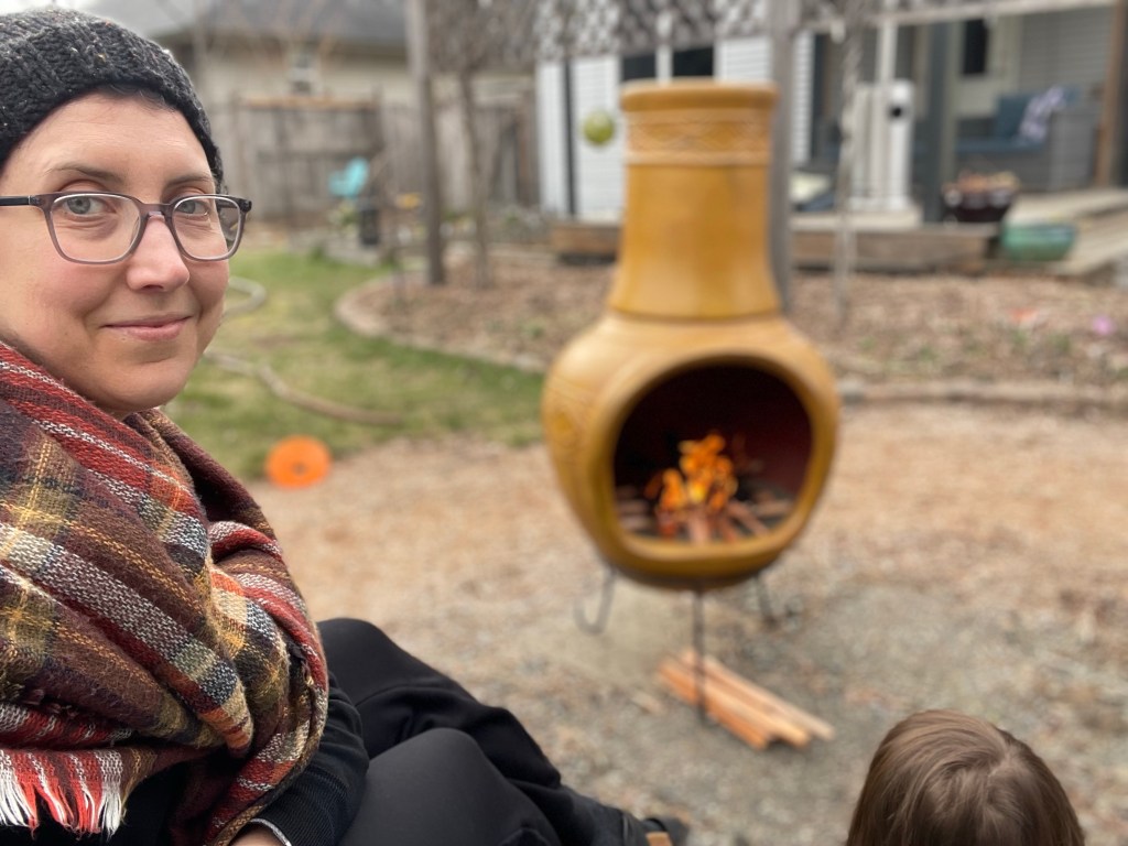 Smiling back at the camera, rugged up by the fire